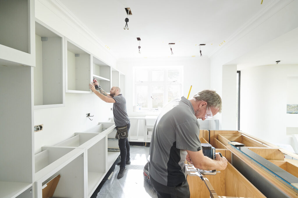 Workers installing kitchen cabinets during a home remodeling project